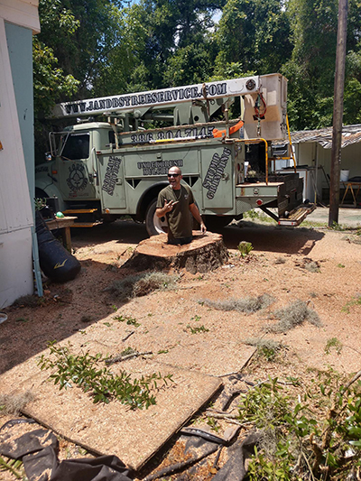 J&B's crew with bucket truck after grinding a stump